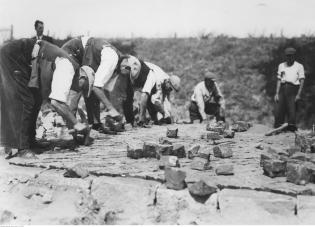 Układanie nawierzchni z kostki bazaltowej na trasie Poznań-Swarzędz (między Poznaniem a Gnieznem), 1935 r. Źródło: Narodowe Archiwum Cyfrowe