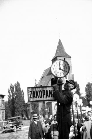 Pracownik ustawiający na wskaźniku godzinę odjazdu autobusu. Czerwiec 1932 r. Fot. Narodowe Archiwum Cyfrowe