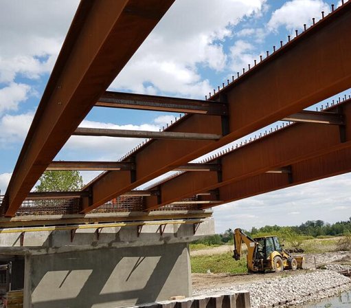 Most zespolony w Wirkowicach nad rzeką Wieprz: dźwigary główne i tymczasowe trawersy stalowe montowane w trakcie budowy. Źródło: ArcelorMittal