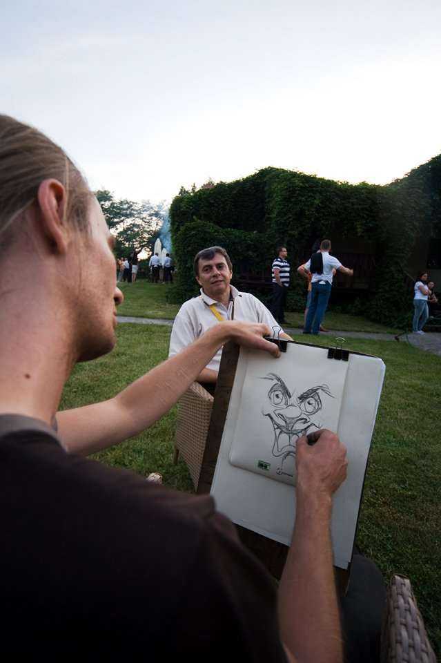Rysownik - karykaturzysta sporządza portrety uczestników Konferencji podczas biesiady grillowej